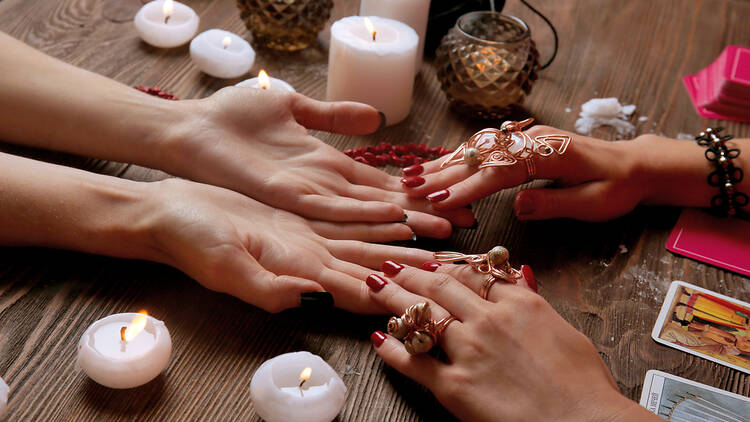 A person getting their palms read by a fortune-teller.