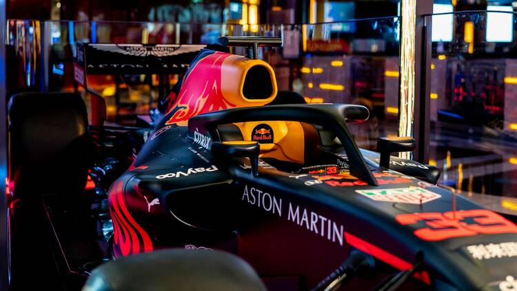 An Aston Martin Formula 1 car inside a glass viewing case, viewed from the side.