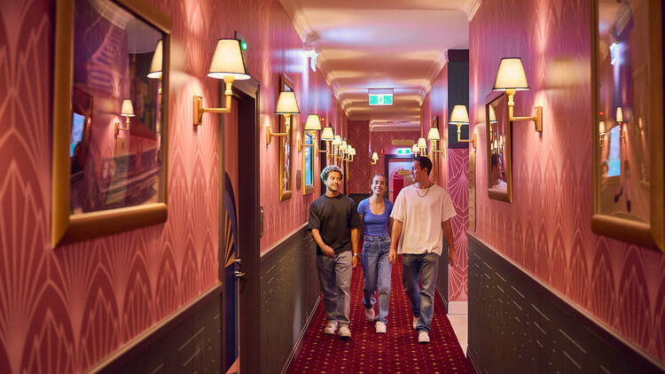 Three friends walking down the hallway at Hijinx Hotel