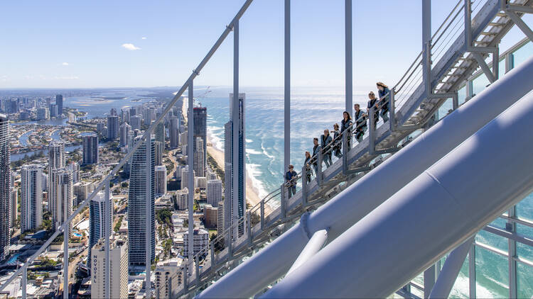 A group of visitors to the Sky Point Climb look out over Surfers Paradise