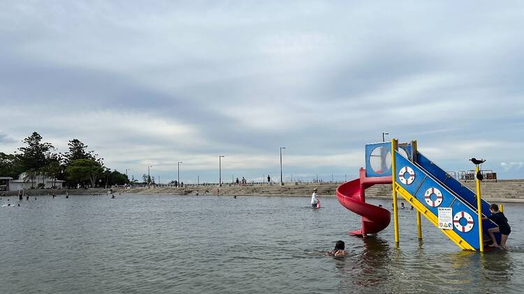 A small waterslide in a large wading pool