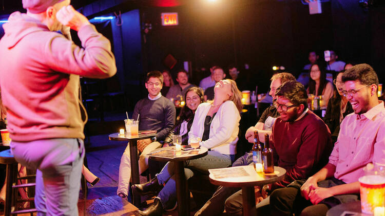 People laugh during a comedy performance.
