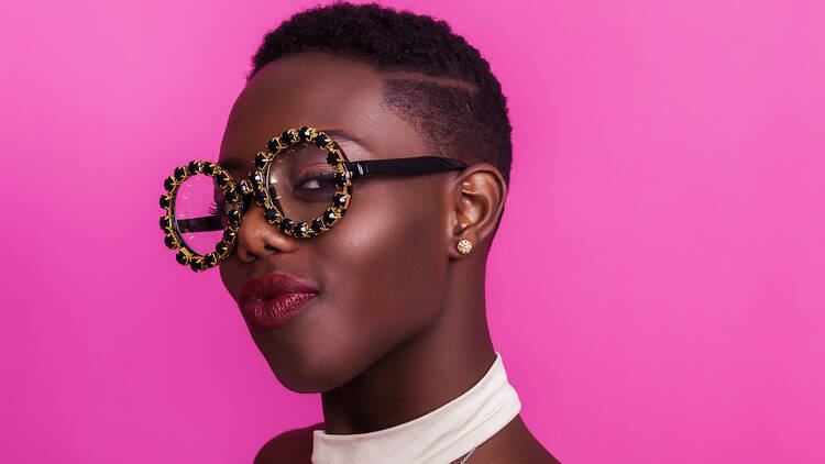 A woman wearing fun round glasses and smiling