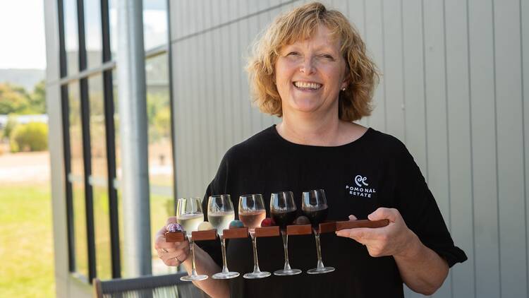 A woman with a tasting flight of wines