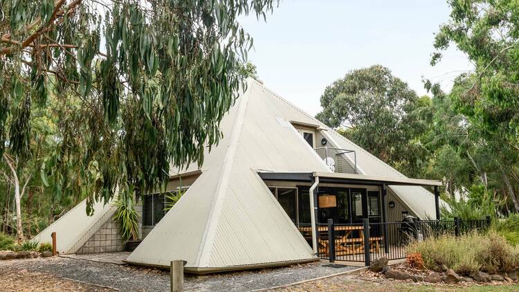 A modern bush cabin shaped like a pyramid 