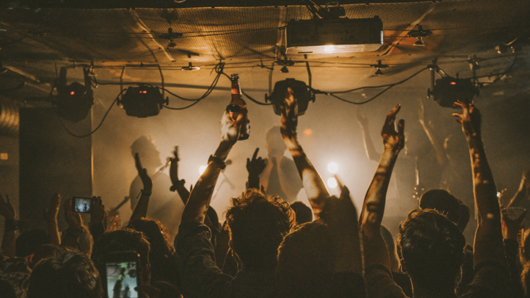 A crowd of people with their hands up in a club