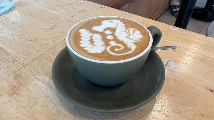 A flat white with a seahorse design