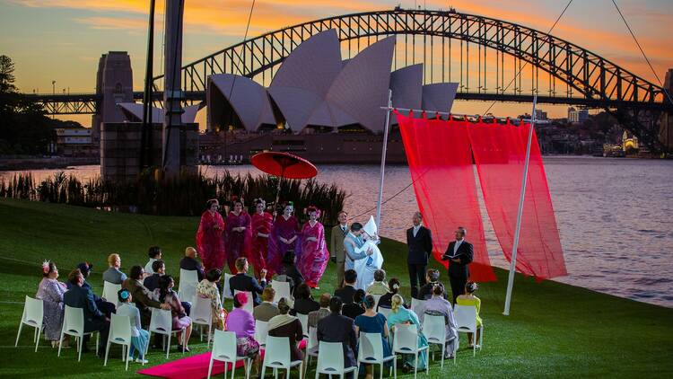 The cast of Madama Butterfly gather in front of Sydney Harbour