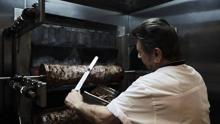 A chef carving meat at Stalactites.