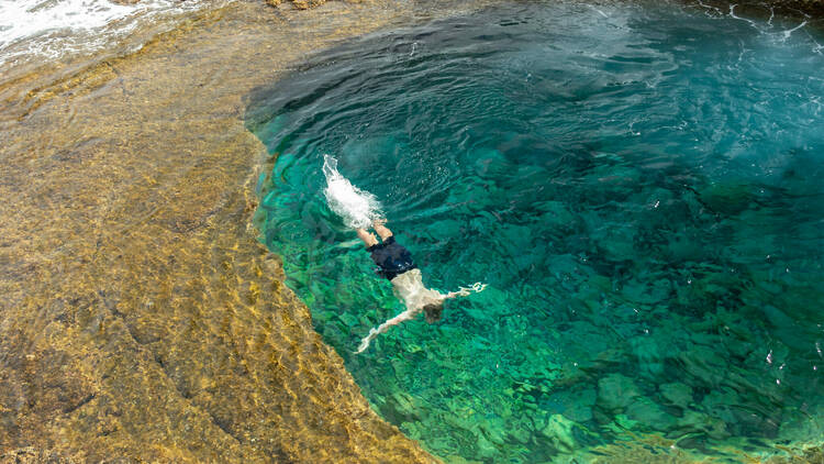 Man diving in a natural pool on the Fuerteventura coastline 