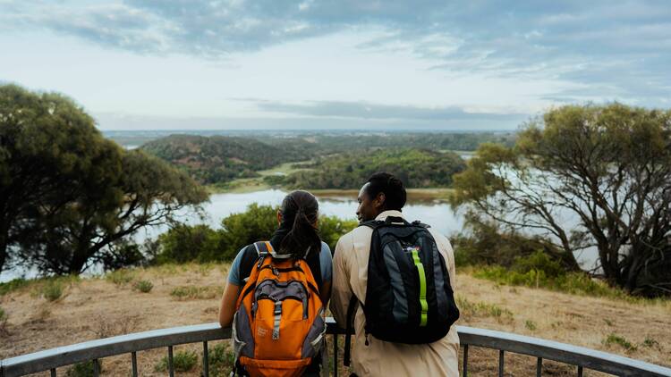 A man and a woman leaning against a rail at a lookout at Tower Hill.