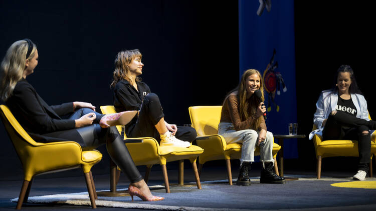Women, including Grace Tame and Chloe Hayden, speaking on a panel.