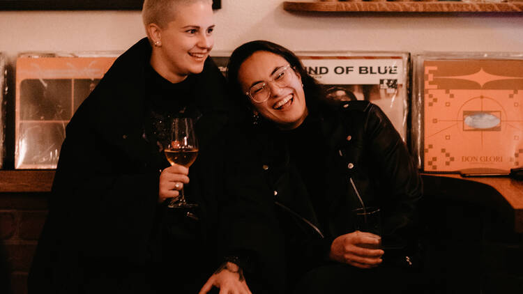 Two people sitting and enjoying glasses of wine.