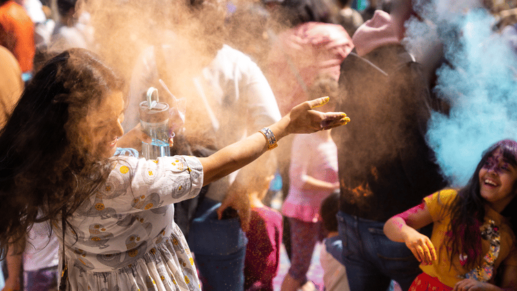 People toss colorful powder during a Holi celebration.