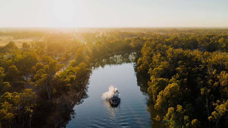 A paddle steamer going down the Murray River at dusk.