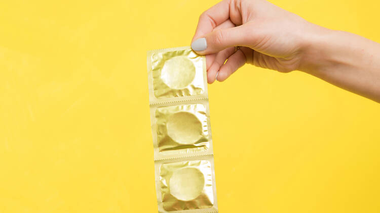 Woman holding condom packets 