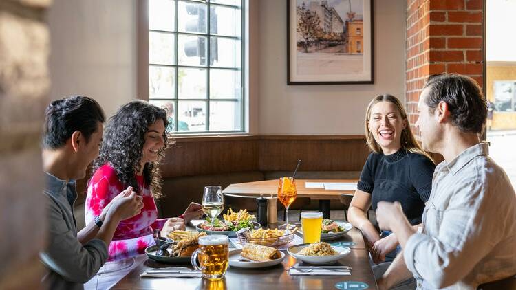 A group of friends enjoy pub food in the dinning hall.