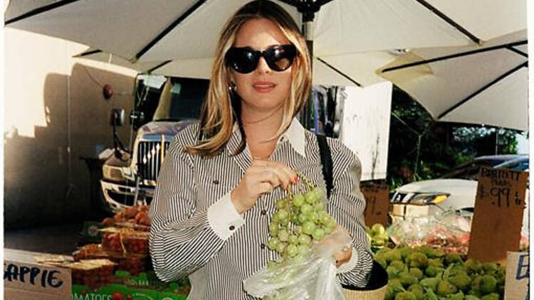 Alison Roman holding some grapes and wearing sunglasses 