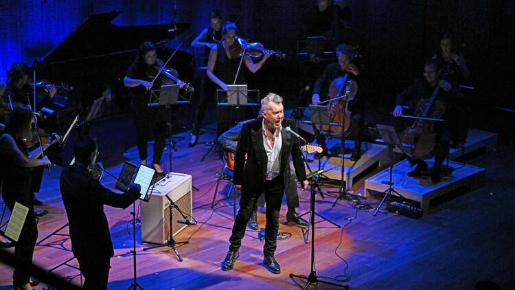 Jimmy Barnes sings on-stage with an orchestra.