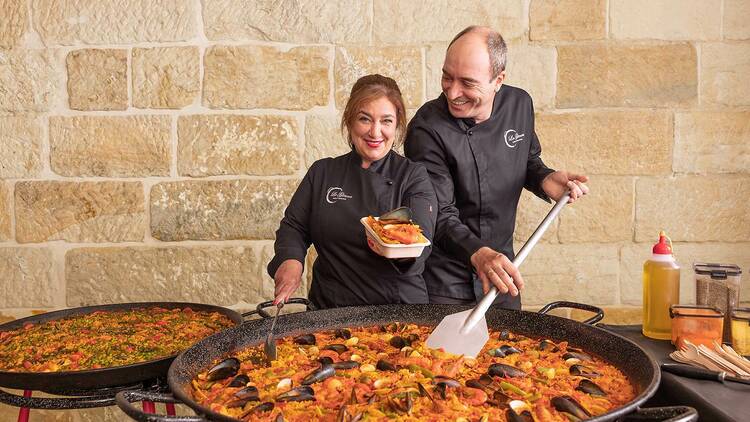 Paella makers with a huge pan of paella