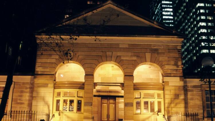 The facade of the Justice and Police Museum lit golden at night.