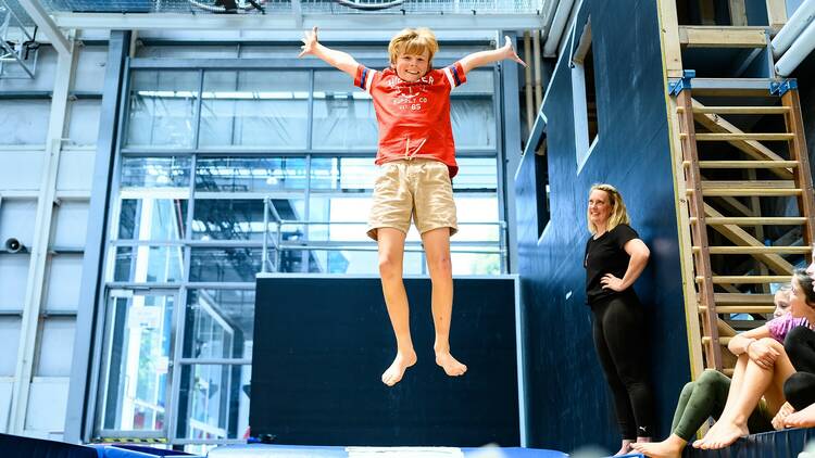 A boy jumps on a trampoline. 
