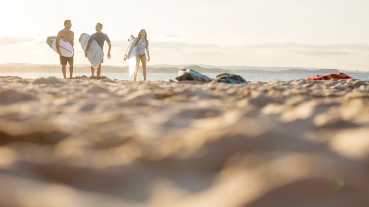 Three surfers on a beach