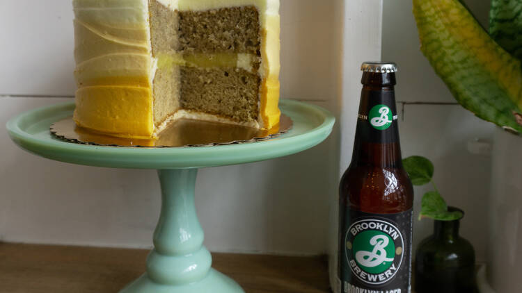 A cake sits next to a bottle of Brooklyn Lager.