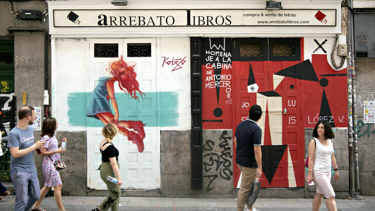 Público paseando frente a la fachada de una librería pintada por los artistas Kolejo y Paul Lataburu
