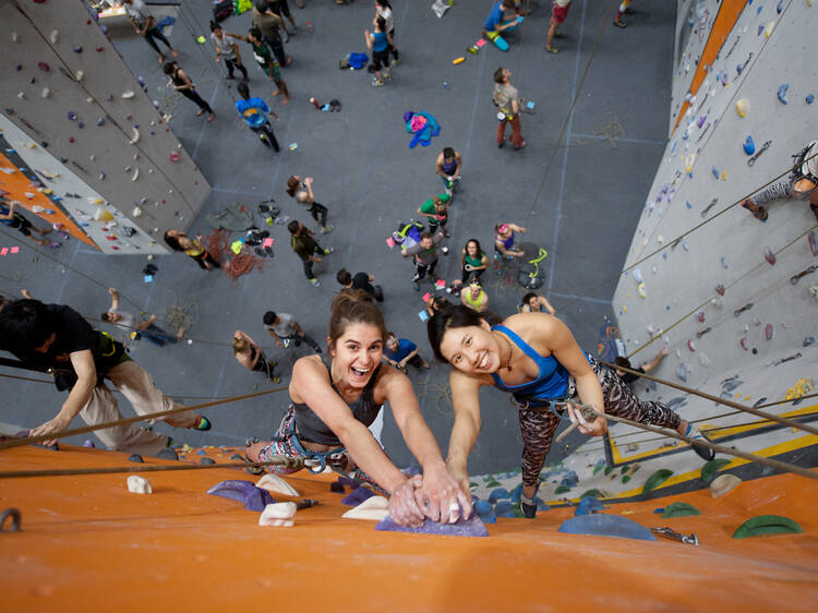 Two people climbing a wall