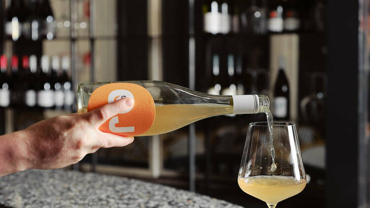 A person pouring a natural wine into a glass.
