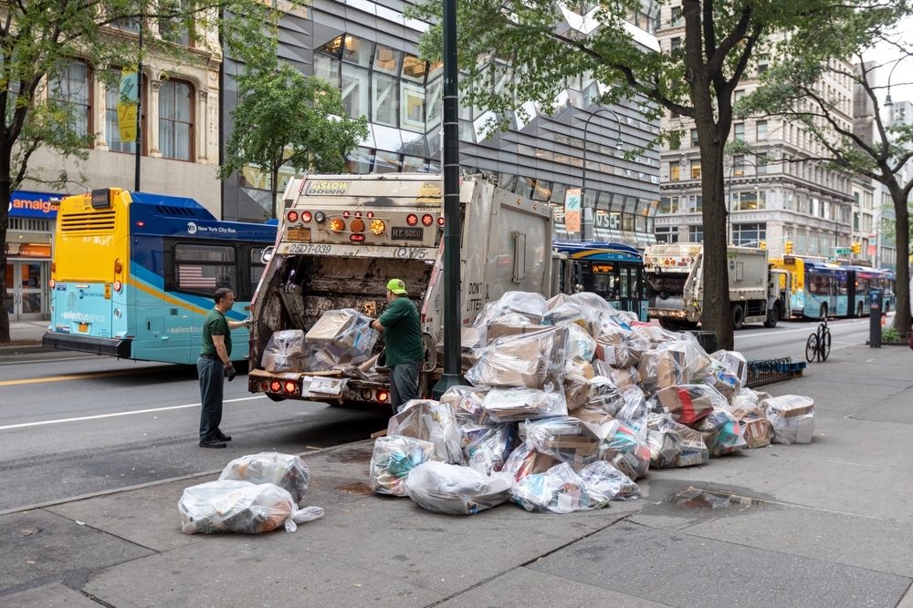 Sanitation workers throwing recycled materials into a truck