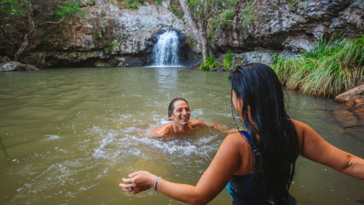 Two people swim in Kondalilla Falls