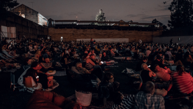 People watch a movie at night outside