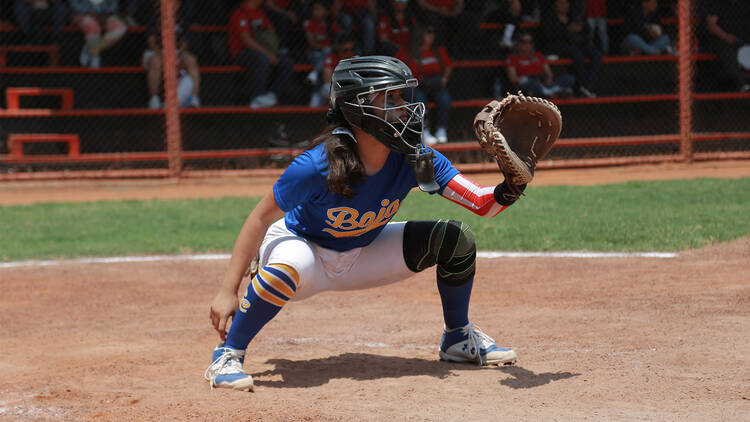 Niña catcher en el posición para recibir una bola