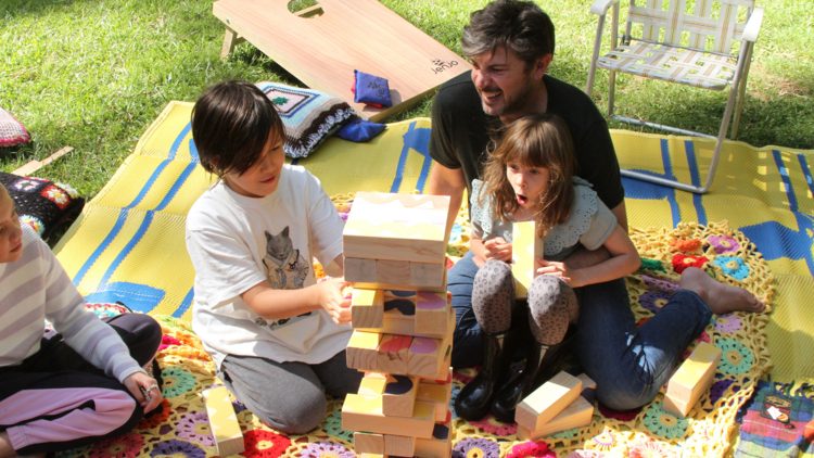 Kids building a block tower with their dad