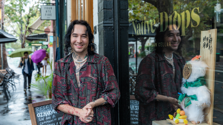 A shop owner standing outside his wine shop