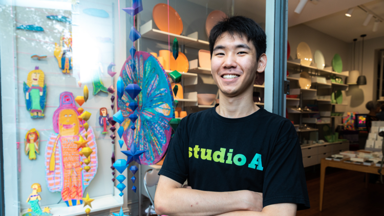 A shopholder standing in front of an art shop