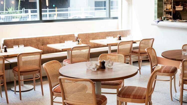 Tables and chairs in a sunlit cafe.