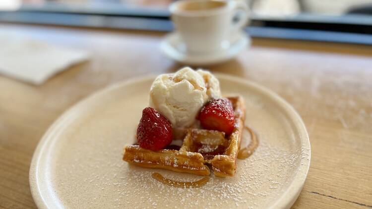 A waffle dish with ice cream and strawberries