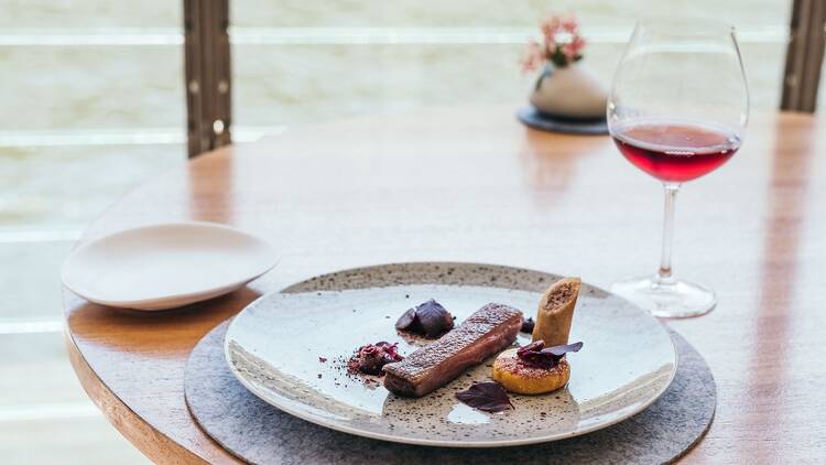 A fish dish and a glass of wine at Berowra Waters Inn with the Hawkesbury River outside