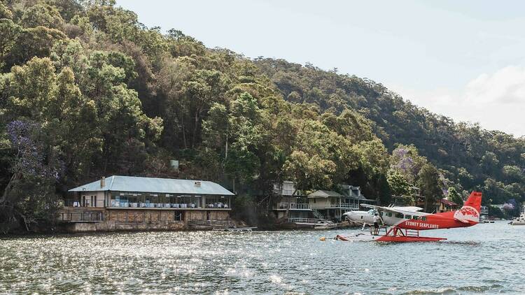 A seaplane on the water next to Berowra Waters Inn on the Hawkesbury River