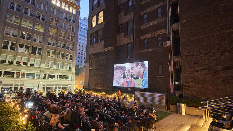 People watch a movie on a rooftop.