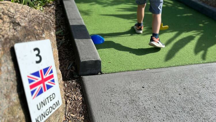 A child playing mini golf