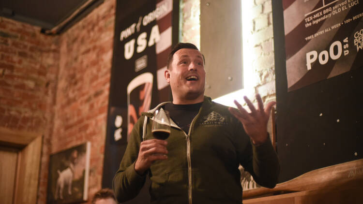 Man orating with a glass of beer