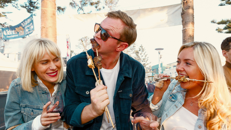 Three people eating kebabs