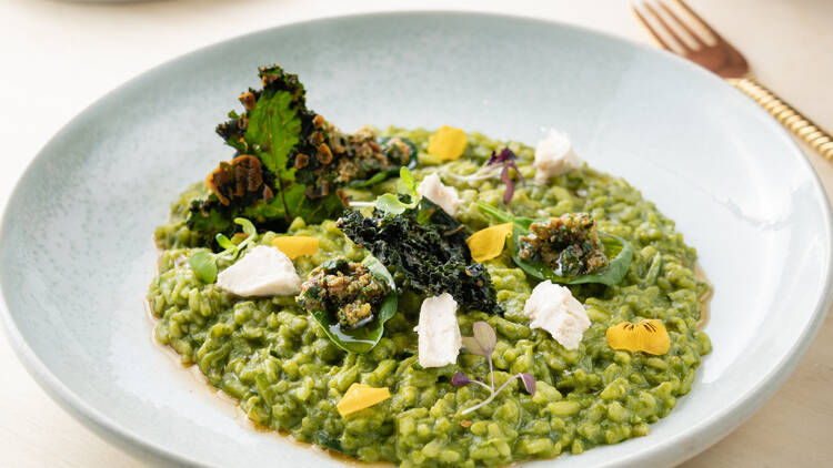 Bowl of green goddess risotto with a fork.