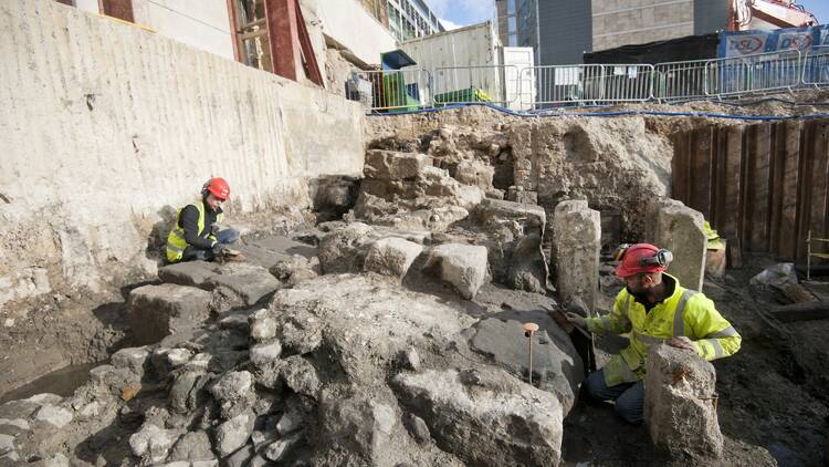 Two archeologists excavating the Roman wall at the City of London