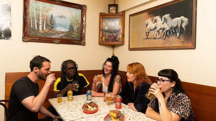 Five friends having a drink and food at a table