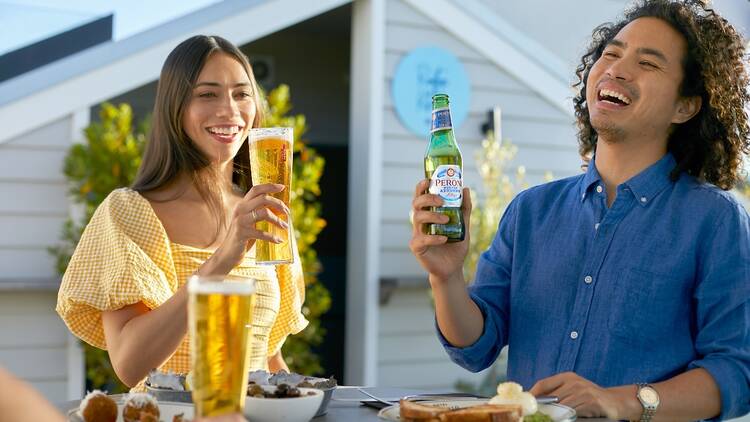 A couple outside enjoying a Peroni beer